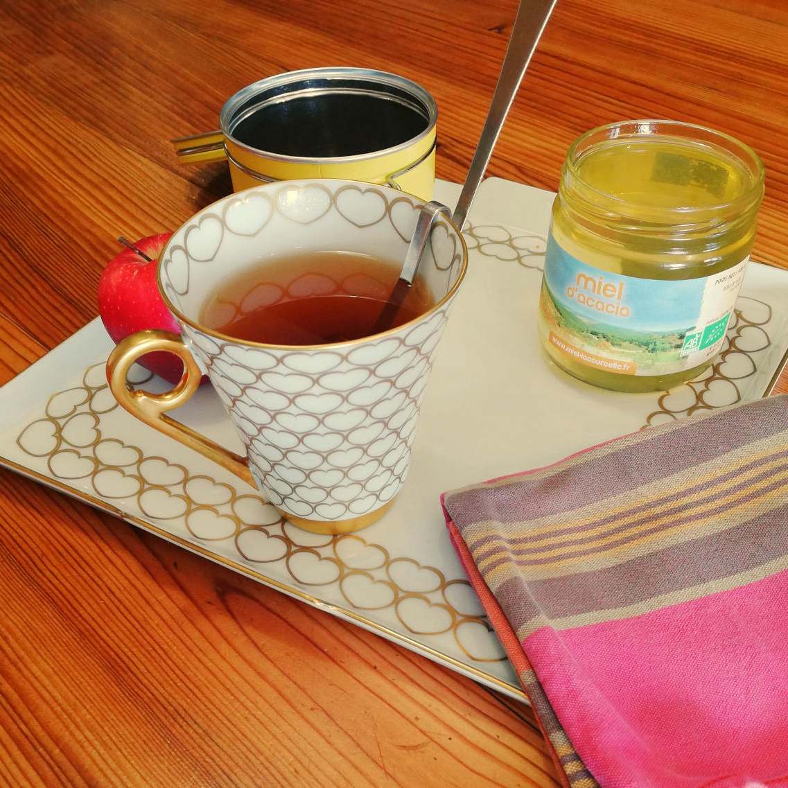 tasse de thé accompagnée d'une cuillère de miel d'acacia bio